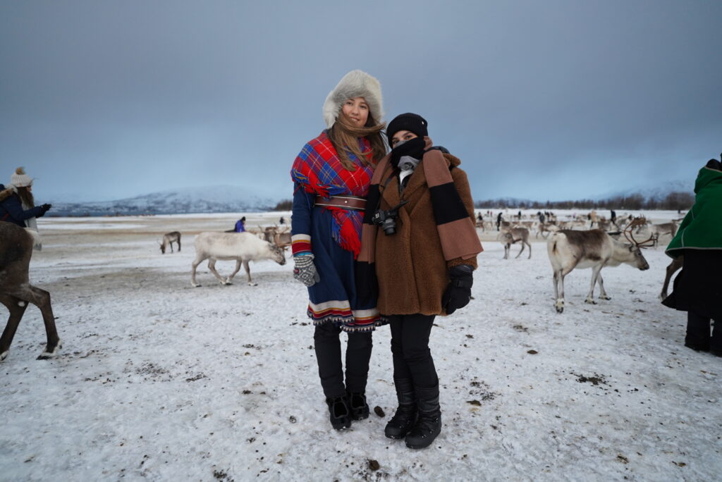 Guests in traditional Sami clothing at a reindeer camp